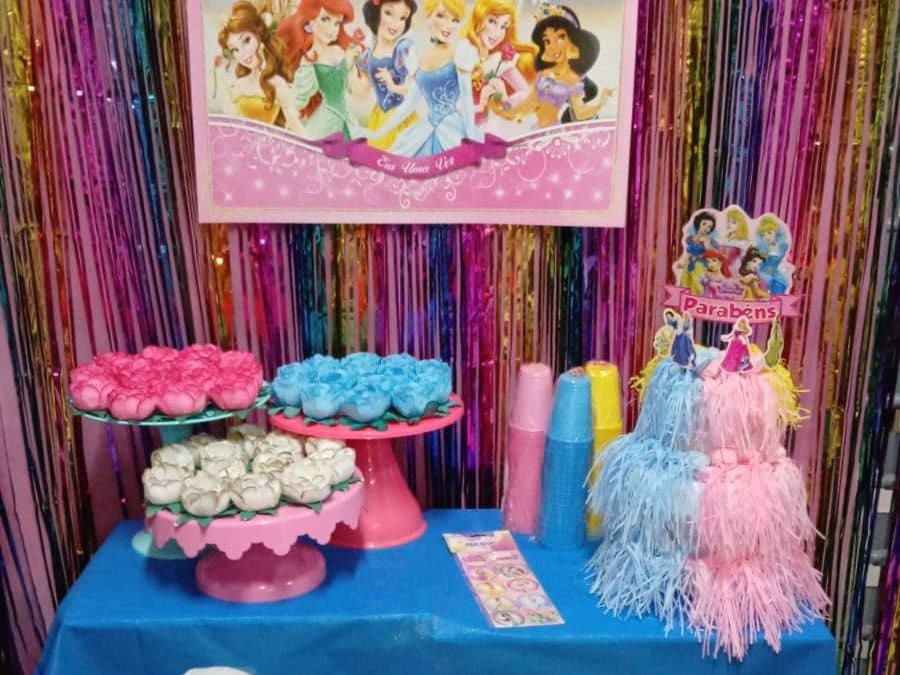 Mesa do tema Princesas na Comemorando Festas, com painel, suportes de doces em tons pastel e topo de bolo